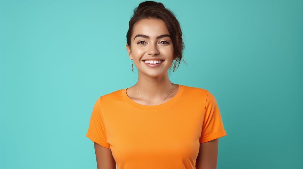 Happy young 19yo dutch woman standing on orange background