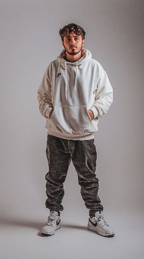 Young man in casual attire posing against a neutral background