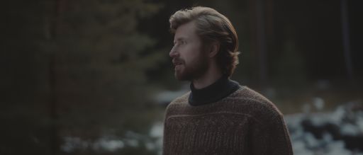 Man in vintage christmas sweater in swedish forest