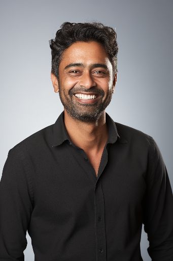 Studio shot of a smiling indian man in black top
