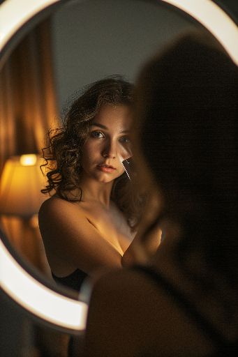 Woman reflected in a mirror with warm ambient lighting
