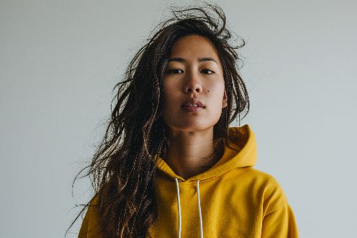 Confident young woman in a yellow hoodie with a neutral expression